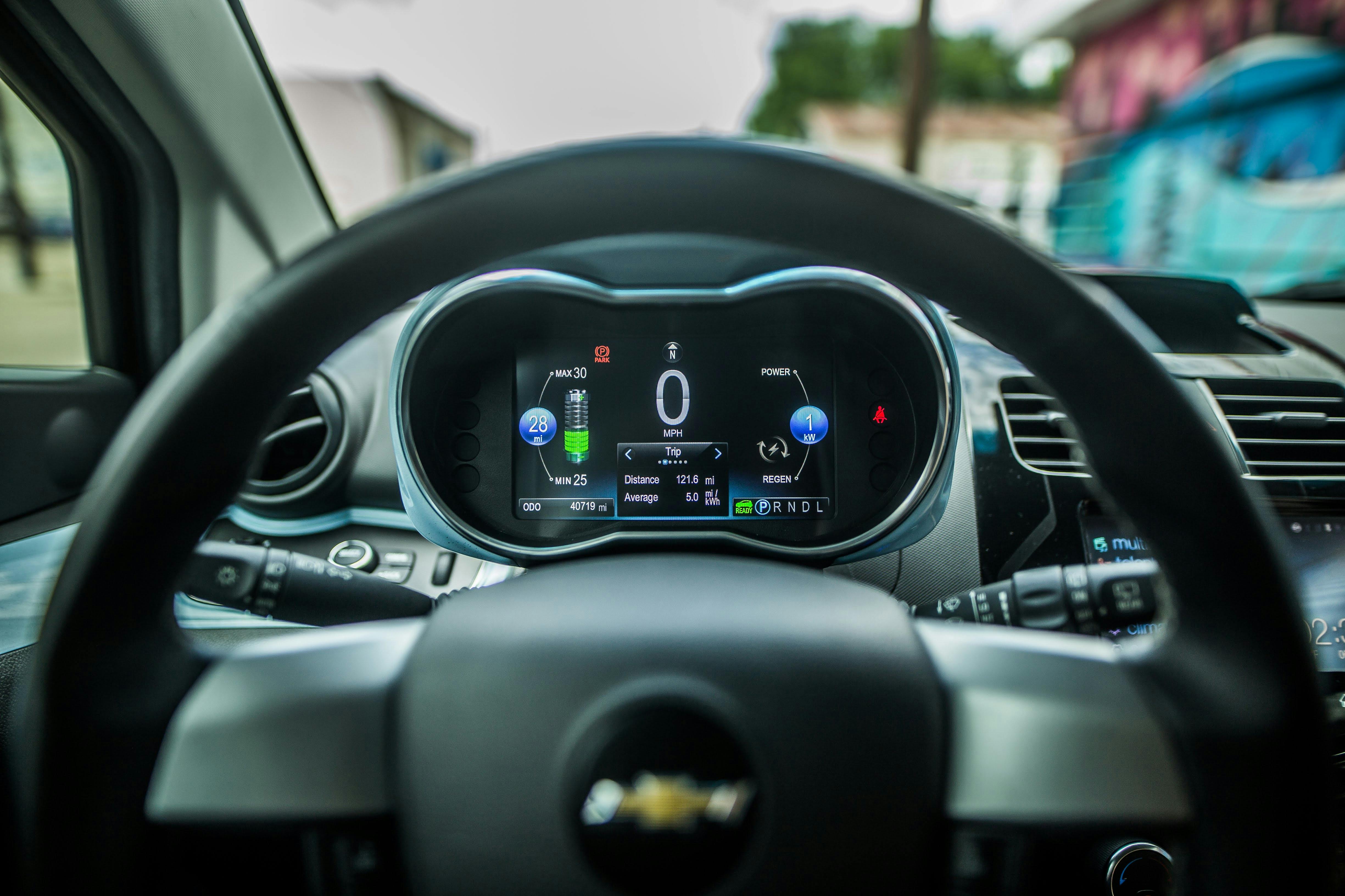 Close-up of a smiling driver behind the wheel of a modern car with a digital insurance shield overlay representing peace of mind